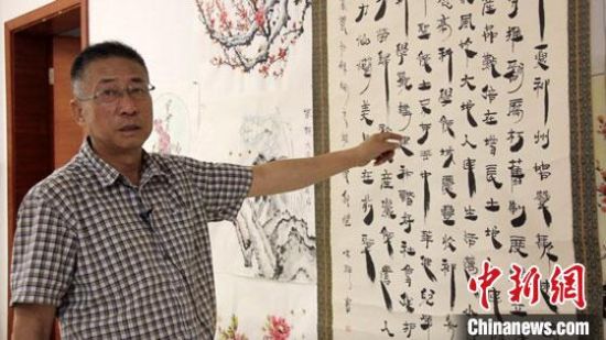 圖為朱群和他的敦煌漢簡(jiǎn)書(shū)體?！「攥?攝