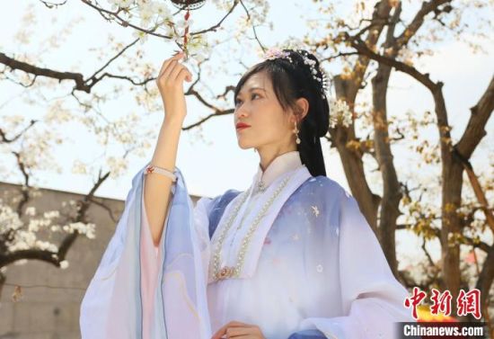 圖為蘭州青年身穿漢服在百年梨園賞景?！「哒?攝