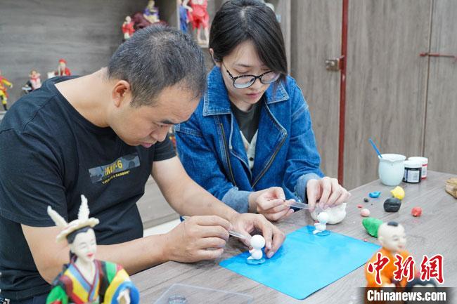 <a target='_blank'  data-cke-saved- >中新社</a>記者(右)現(xiàn)場(chǎng)體驗(yàn)面塑制作過(guò)程?！￡悹?zhēng)強(qiáng) 攝