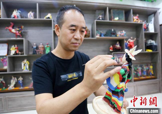 圖為安秋平正在創(chuàng)作代表隴南文縣民俗的《白馬人》作品。　高展 攝