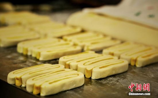 圖為面劑被涂上胡麻油，切成條狀用作月餅的花型制作。張文 攝