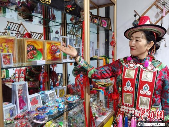 圖為身著民族服飾的隴原巧手展示手工藝品。(資料圖) 徐雪 攝