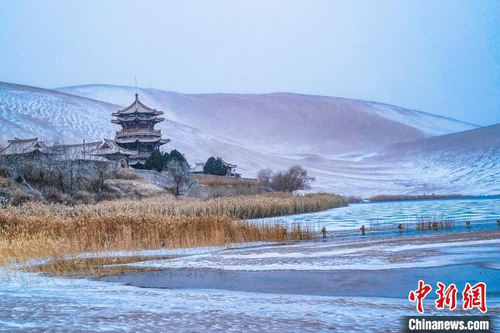 2021年11月28日，雪落鳴沙山月牙泉景區(qū)。　王斌銀 攝