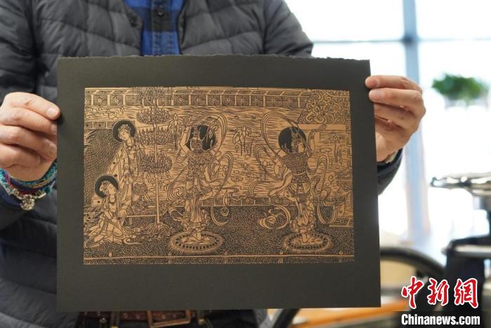 圖為手工書藝人展示敦煌雕版壁畫印刷品?！【琶赖┰?　攝