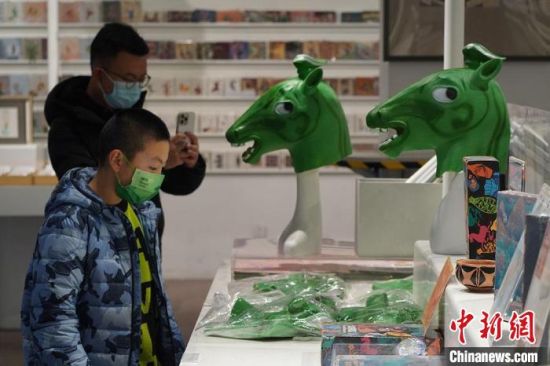 圖為“神馬來了”銅奔馬頭套吸引參觀者駐足?！【琶赖┰?攝