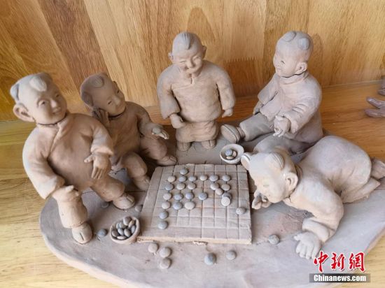 圖為泥塑作品展現(xiàn)下棋場景。 劉玉桃 攝