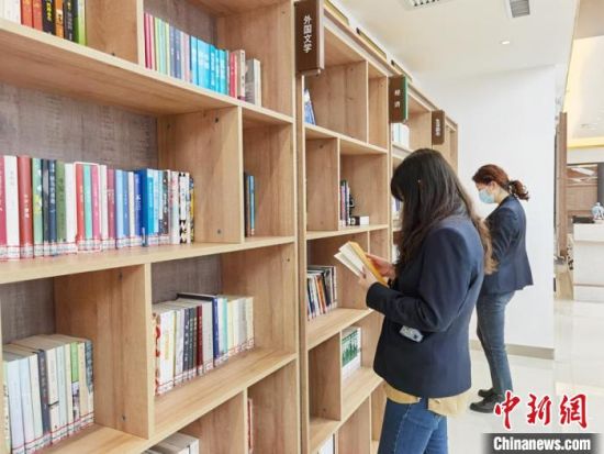 圖為在甘肅公航旅建設(shè)集團有限公司的職工書屋，職工挑選書籍?！⌒煅?攝