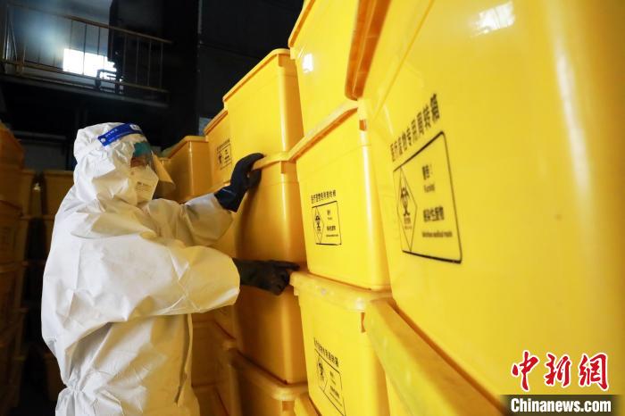 圖為工作人員搬運醫(yī)療廢物專用周轉(zhuǎn)箱?！∥航ㄜ?攝