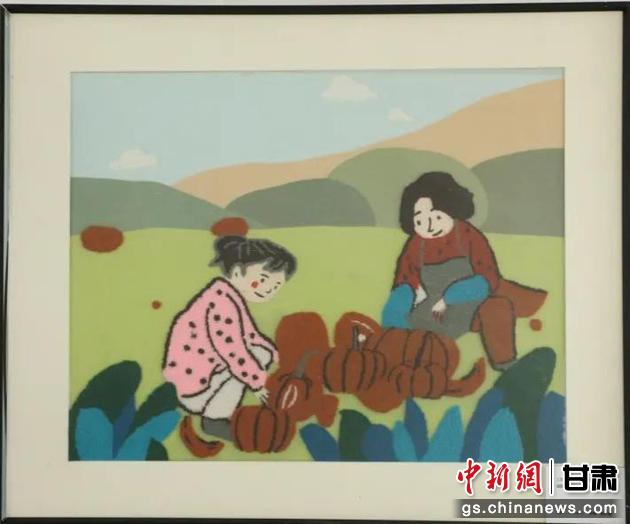 嘉峪關(guān)市新城鎮(zhèn)新城村農(nóng)業(yè)產(chǎn)業(yè)園區(qū)內(nèi)，母女兩人在摘南瓜。刺繡 馬艾米乃 繡稿 敬紅霞