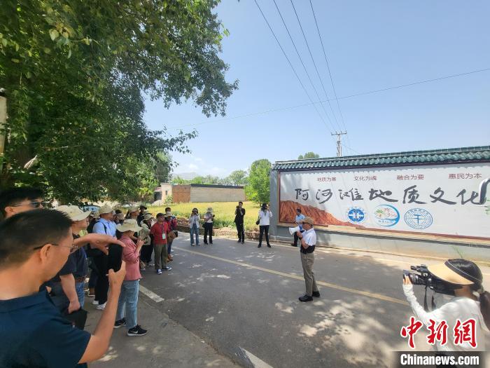 圖為中國地質(zhì)大學(北京)教授張緒教介紹村落情況?！『衍?攝