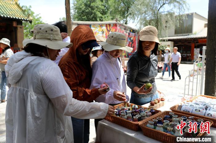 圖為民眾挑選手工藝產(chǎn)品?！⊙Φ?攝