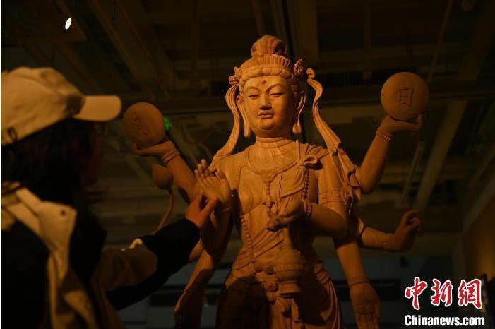 圖為季茂杰觀察自己創(chuàng)作的敦煌木雕。李亞龍 攝</p>
<p>