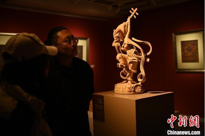 圖為季茂杰向參觀者介紹自己創(chuàng)作敦煌木雕的過程。李亞龍 攝</p>
<p>