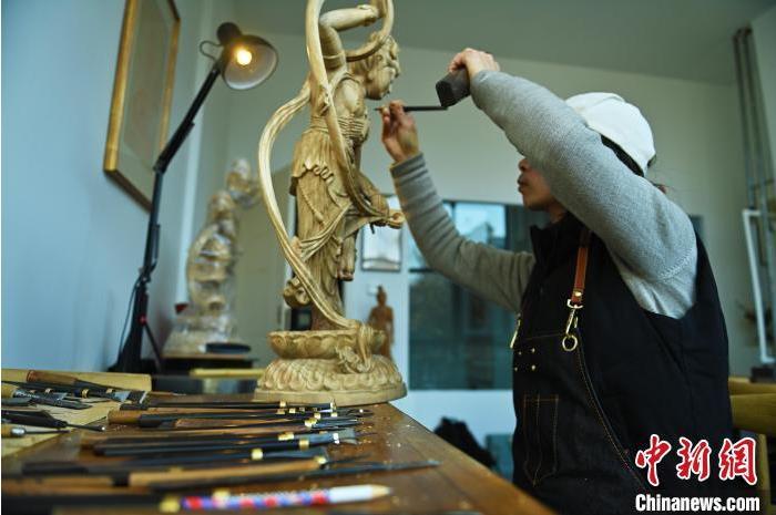 圖為季茂杰進行敦煌元素的木雕創(chuàng)作。李亞龍 攝</p>
<p>