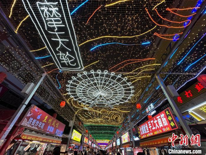 圖為明清街夜市燈光點(diǎn)亮具有武威文化元素的“摩天輪”彩燈。　戴文昌 攝</p><p>