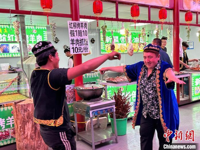 圖為餐飲經(jīng)營者在“西涼不夜城”跳起舞蹈引客?！〈魑牟?攝</p><p>