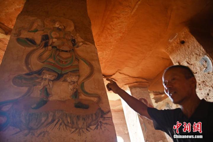 7月15日，甘肅省平?jīng)鍪袥艽h百里石窟長廊羅漢洞石窟內(nèi)，該窟文保員郭建平介紹窟內(nèi)石刻彩繪壁畫。郭建平家中三代人曾自發(fā)保護羅漢洞石窟。羅漢洞石窟遺存40余個窟龕，以北魏至清代風格為主。中新社記者 李亞龍 攝</p>
<p>