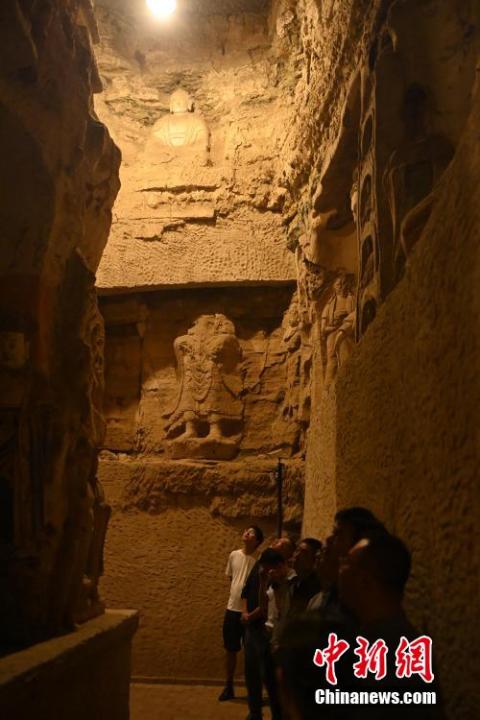 7月15日，游人參觀甘肅省平?jīng)鍪袥艽h百里石窟長廊中的王母宮石窟。百里石窟長廊位于涇川縣境內(nèi)，由512個石窟、5眼窟中石井組成，現(xiàn)存王母宮石窟、鳳凰山石窟、南石窟寺、丈八寺石窟、羅漢洞石窟、太山寺石窟等規(guī)模較大的石窟群，還有數(shù)量眾多的小石窟群。王母宮石窟又名千佛洞，該窟設(shè)計宏大，造像生動，窟內(nèi)擁有造像數(shù)百尊，是較為珍貴的佛教文化遺存。中新社記者 李亞龍 攝</p>
<p>