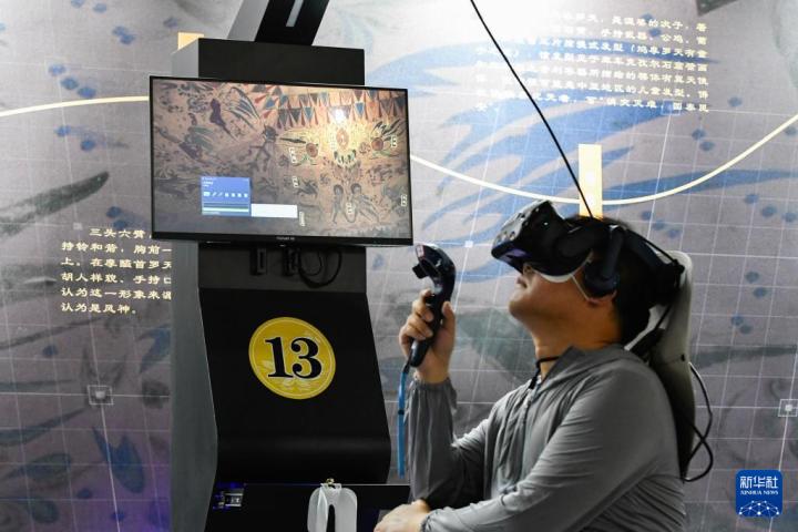 7月22日，游客借助VR設(shè)備沉浸式游覽莫高窟第285窟虛擬場(chǎng)景。新華社記者 郎兵兵 攝